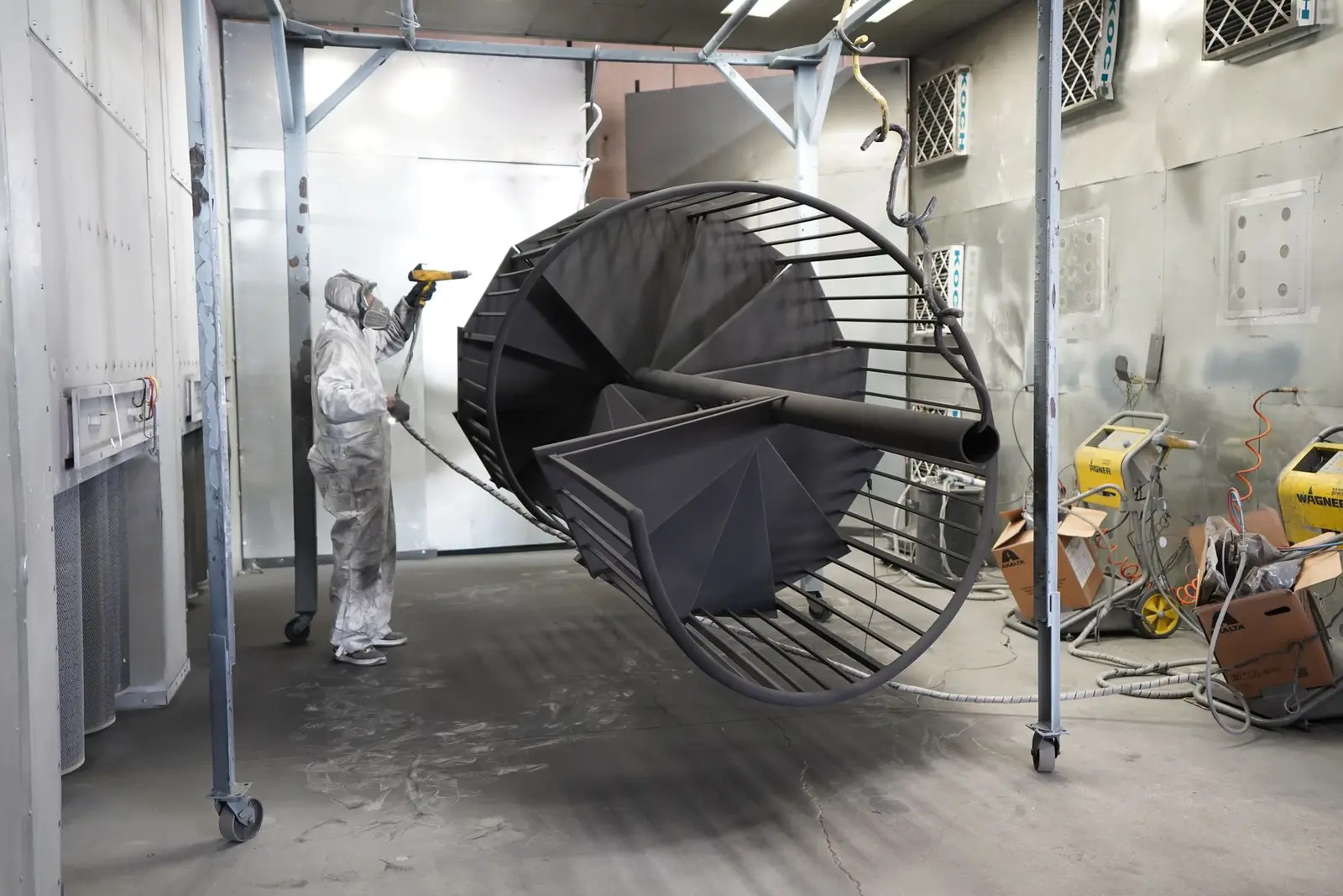 Industrial spray coating being applied to a large fabricated component